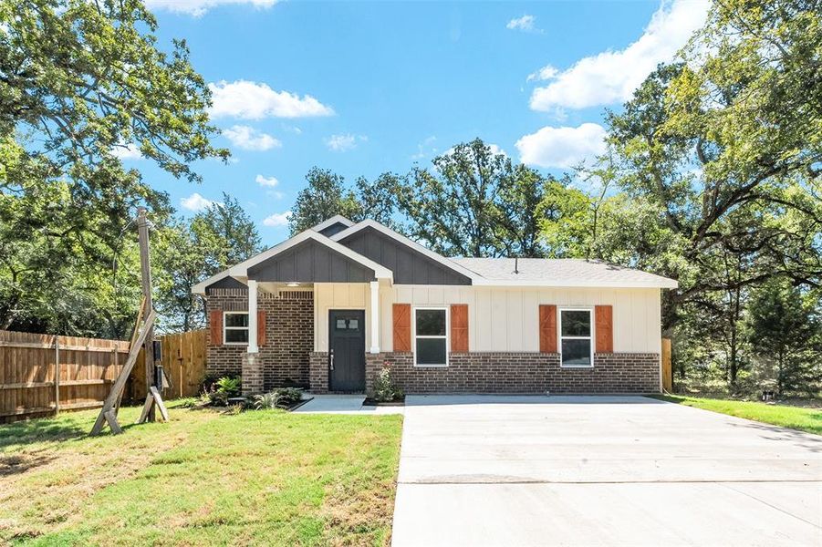 Contemporary single-story residence featuring a dark brick and light siding exterior with decorative wood-finish shutters Contemporary single-story residence featuring a dark brick and light siding exterior with decorative wood-finish shutters