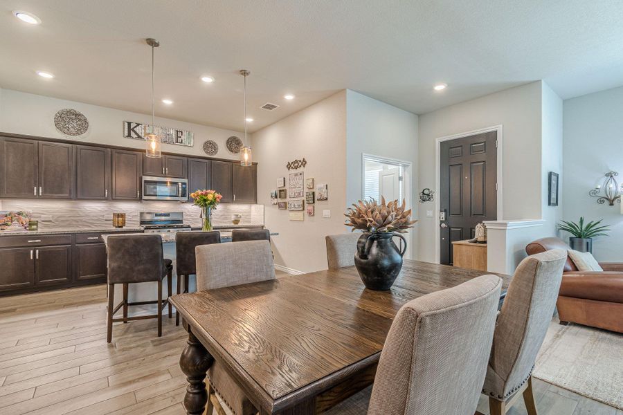 Dining area with light wood finished floors and recessed lighting