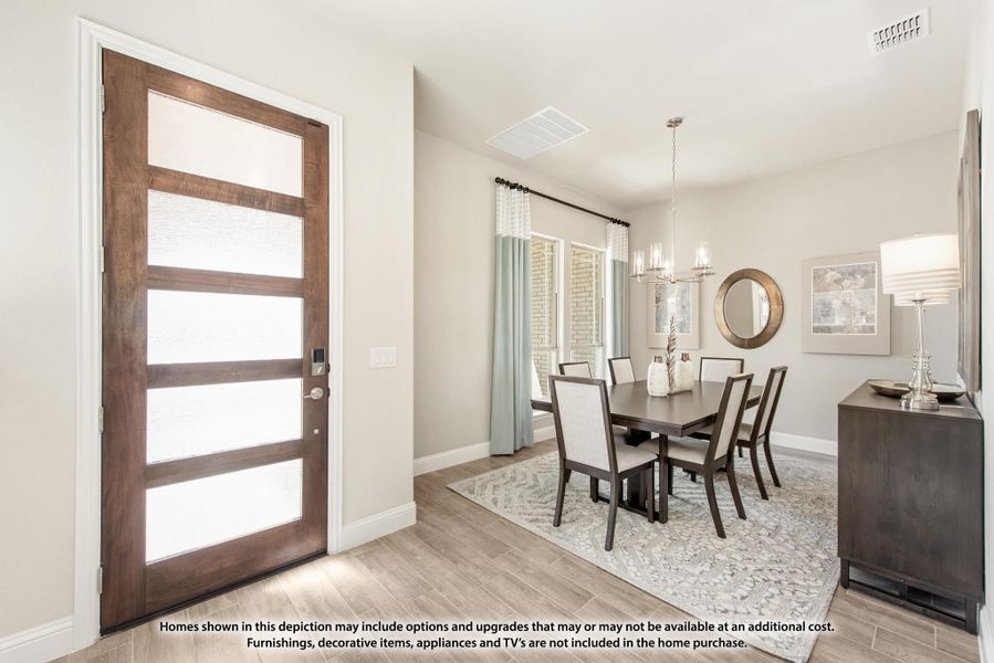 Dining room with dark wood table, chandelier, and modern front door with glass panels nearby Dining room with dark wood table, chandelier, and modern front door with glass panels nearby