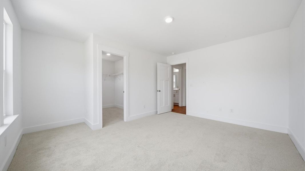 Highly functional bedroom with walk-in closet and tasteful carpet for a restful retreat Highly functional bedroom with walk-in closet and tasteful carpet for a restful retreat