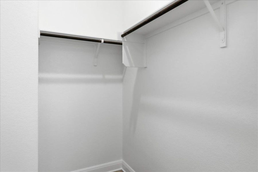 Well-designed walk-in closet with ample hanging space and integrated shelving. Well-designed walk-in closet with ample hanging space and integrated shelving.