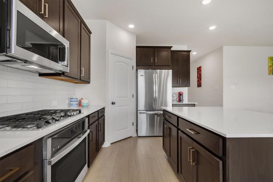 Big beautiful and bright kitchen with gorgeous quartz counters, designer backsplash, stainless cooking and gas range Big beautiful and bright kitchen with gorgeous quartz counters, designer backsplash, stainless cooking and gas range