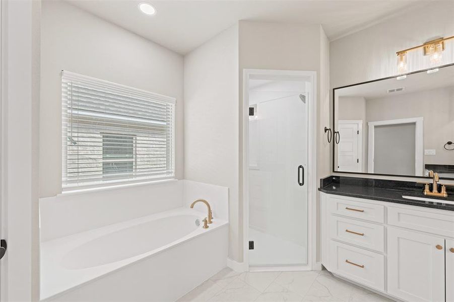 Full bathroom with vanity, a bath, a stall shower, recessed lighting, and light marble finish flooring