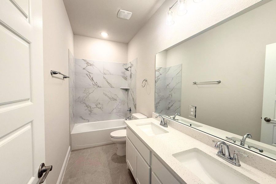 A well-appointed bathroom with a spacious vanity, dual sinks, and a clean, tiled shower-tub combination. A well-appointed bathroom with a spacious vanity, dual sinks, and a clean, tiled shower-tub combination.