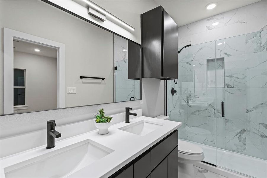 Bathroom featuring vanity, toilet, and an enclosed shower