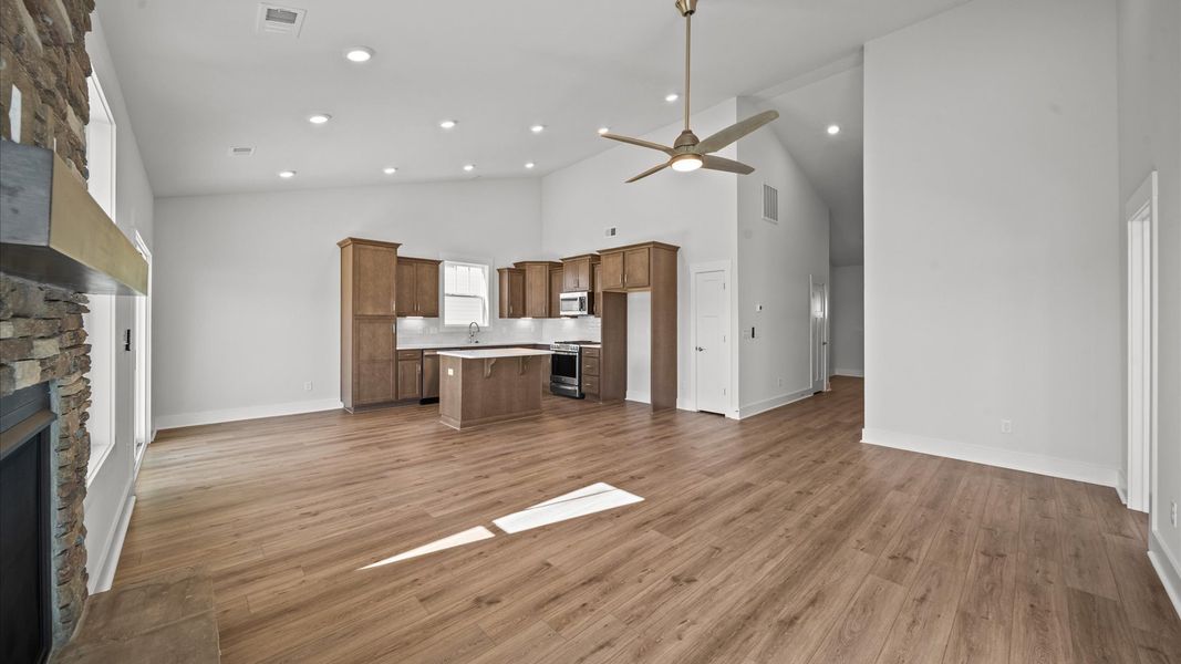Refined and memorable, this family room features a fireplace, two-story ceilings, and top-notch comfort throughout