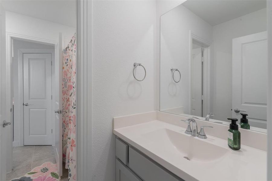 Full bath with vanity and tile patterned floors