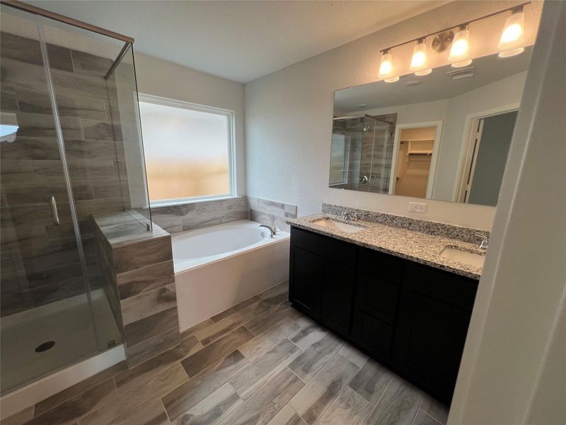 Indulge in a primary bathroom featuring a spacious walk-in shower, soaking tub, and elegant double vanity.