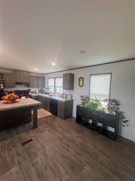 Kitchen featuring dark wood finish cabinetry, black appliances, dark wood-style floors, and recessed lighting Kitchen featuring dark wood finish cabinetry, black appliances, dark wood-style floors, and recessed lighting