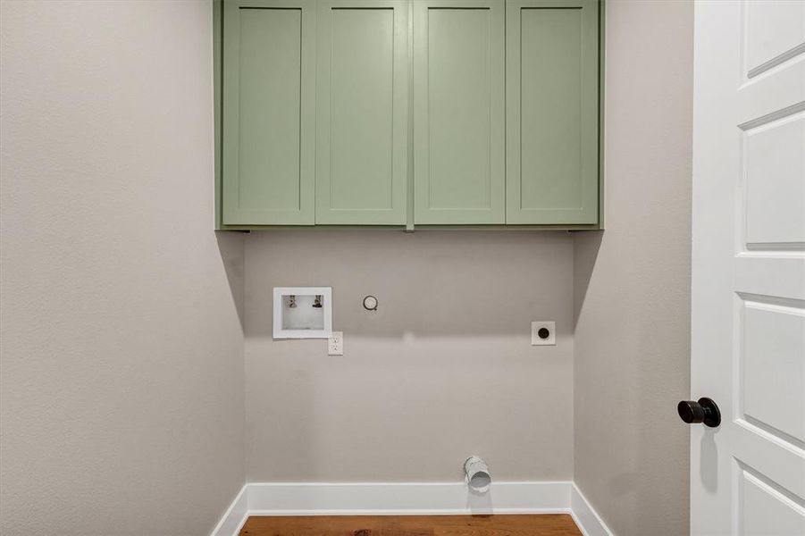 Washroom with wood finished floors, cabinet space, hookup for a washing machine, and hookup for an electric dryer Washroom with wood finished floors, cabinet space, hookup for a washing machine, and hookup for an electric dryer