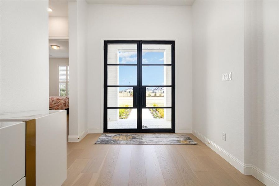 Doorway to outside with wood finished floors and baseboards