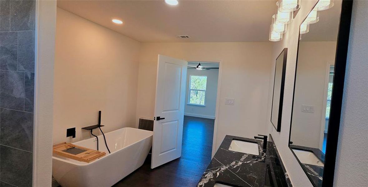 Full bathroom featuring a soaking tub, double vanity, dark wood-style floors, recessed lighting, and a ceiling fan Full bathroom featuring a soaking tub, double vanity, dark wood-style floors, recessed lighting, and a ceiling fan