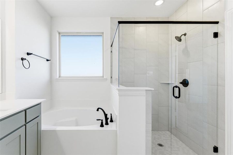 Bathroom featuring a bath, vanity, and a stall shower