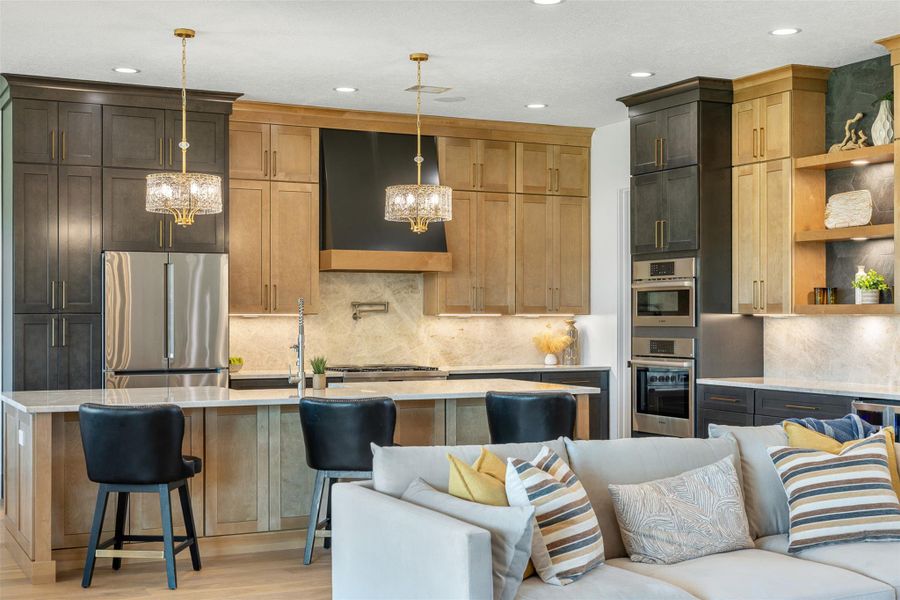 Kitchen featuring freestanding refrigerator, tasteful backsplash, extractor fan, open floor plan, and recessed lighting