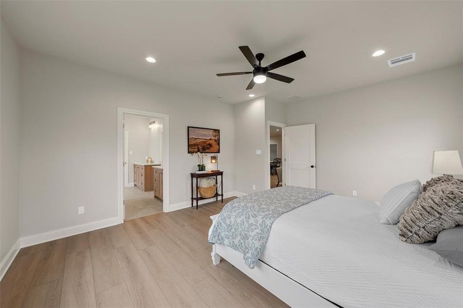 Spacious room featuring wood-finish flooring, recessed lighting, and a contemporary ceiling fan