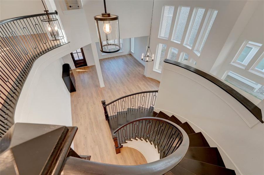 Stairway featuring a chandelier, a high ceiling, and vinyl 
 finished floors