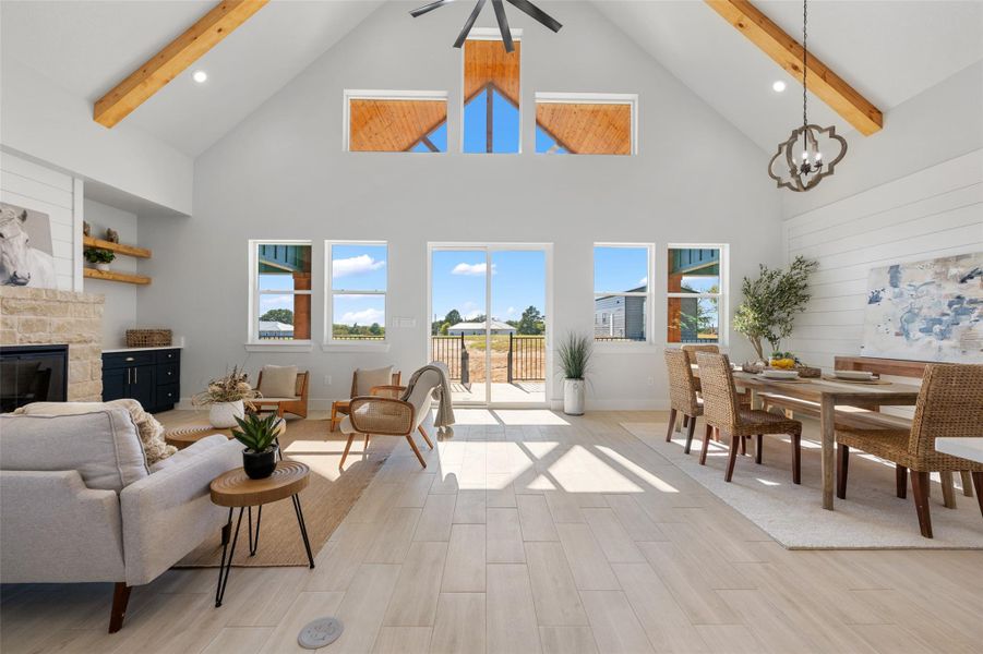 Living room featuring high vaulted ceiling, beamed ceiling, light wood finished floors, a fireplace, and recessed lighting