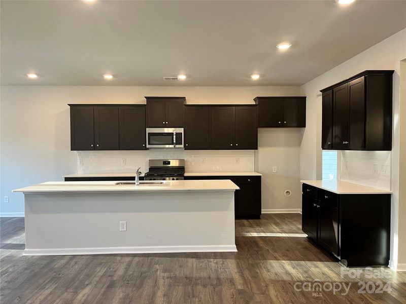 Beautiful contrast with the dark cabinets and white backsplash & countertops!