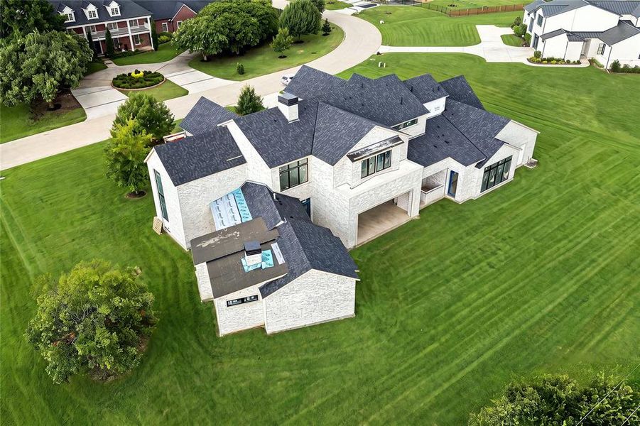 Contemporary residence featuring a light-colored brick exterior and dark shingle roofing