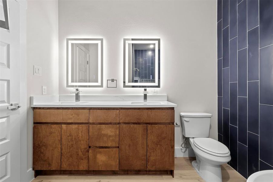 Bathroom with hardwood / wood-style floors, vanity, and toilet