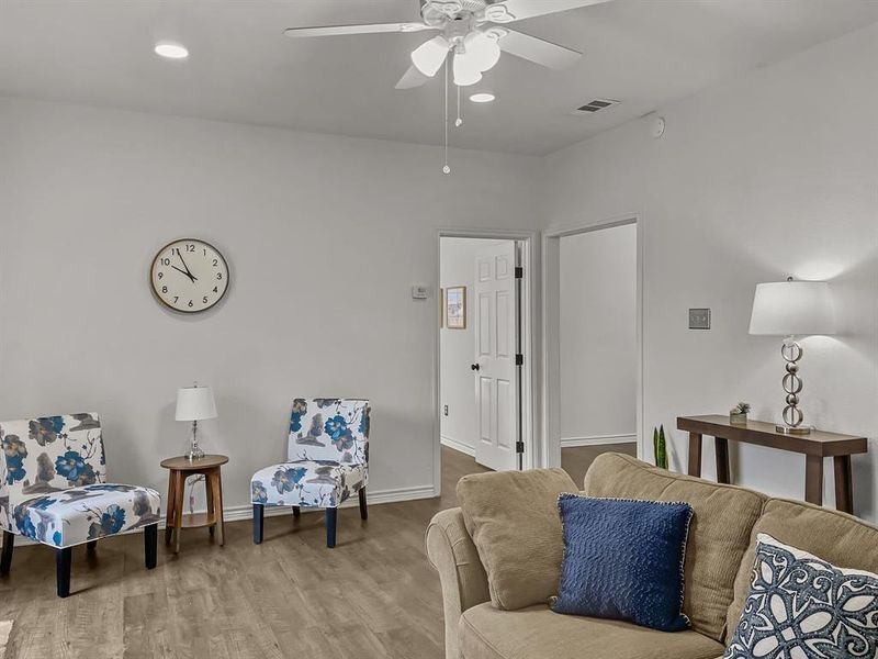 Living room with wood-style flooring and ceiling fan