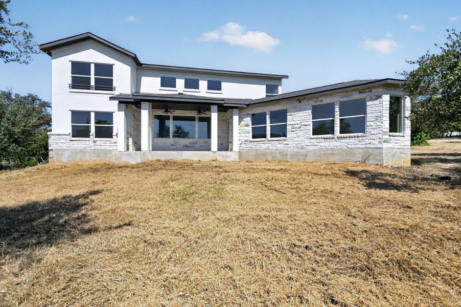 A striking modern facade blends clean stucco lines with rustic stone masonry details.
