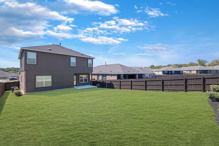 Back of house featuring a fenced backyard, a patio, and a residential view