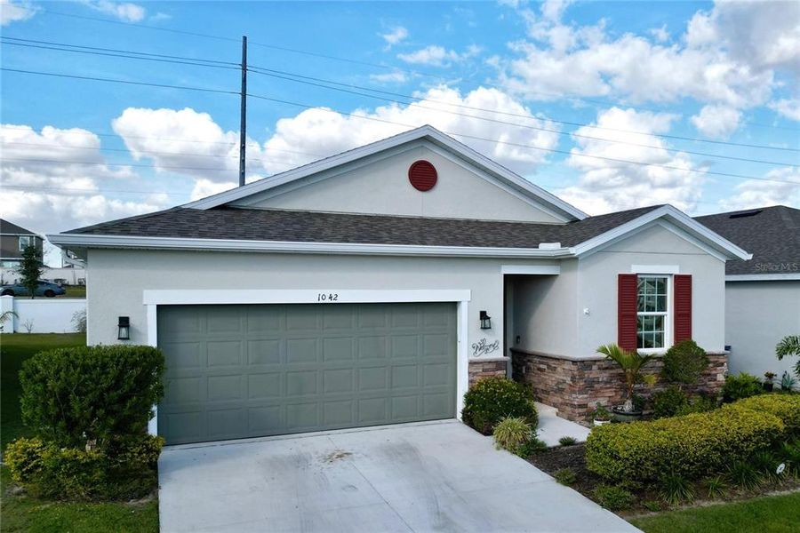 Front exterior of a new home in Seasons at Heritage Square, Haines City, FL, highlighting curb appeal (Image 1). Front exterior of a new home in Seasons at Heritage Square, Haines City, FL, highlighting curb appeal (Image 1).