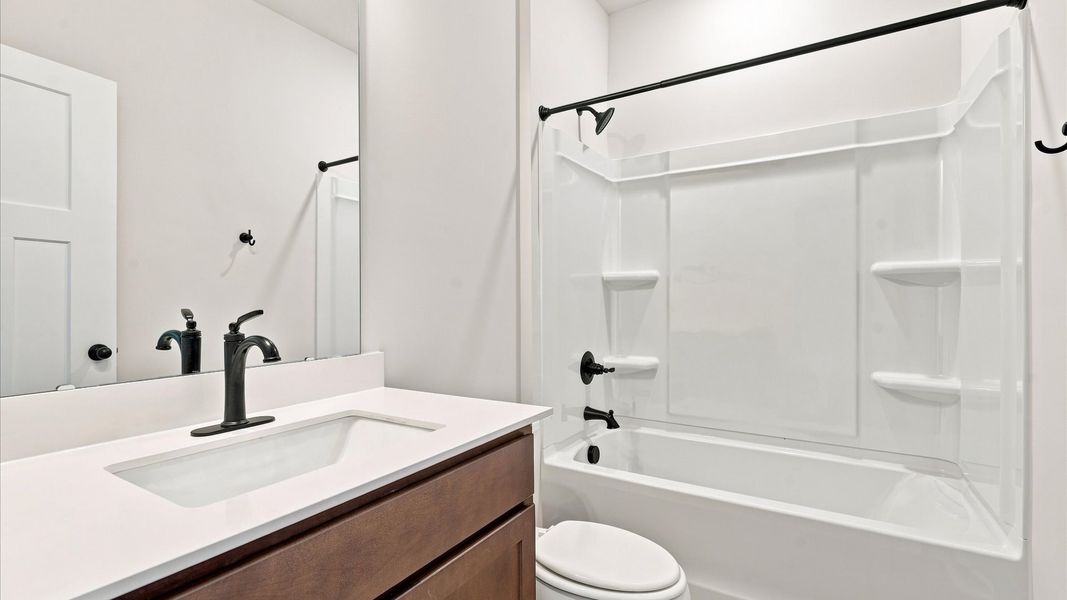 Accomplished bathroom design with sleek tile, high-quality cabinetry, and refined hardware at the Wells Crossing community