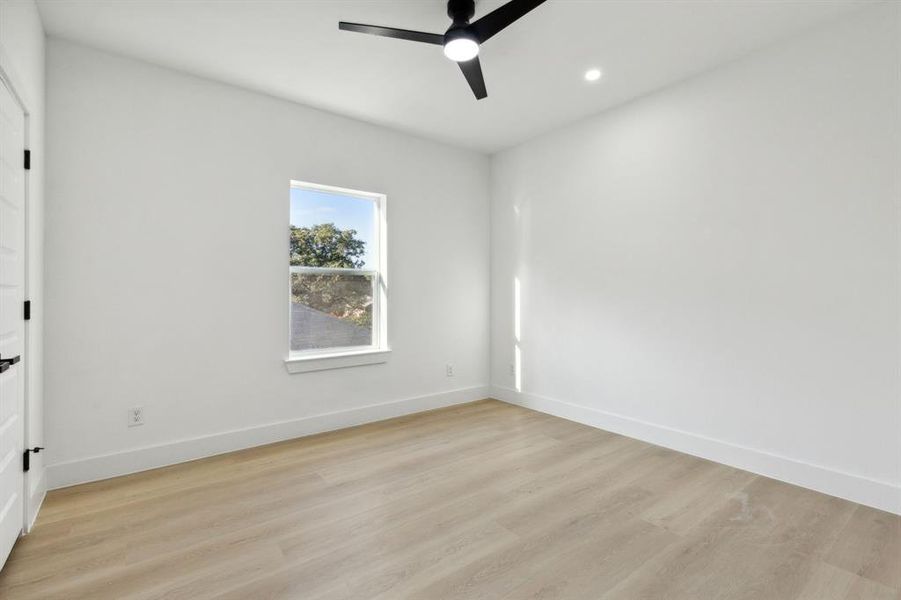 Empty room featuring light wood-type flooring and ceiling fan