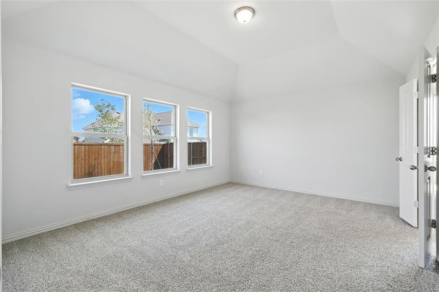 Unfurnished room featuring light colored carpet and lofted ceiling Unfurnished room featuring light colored carpet and lofted ceiling