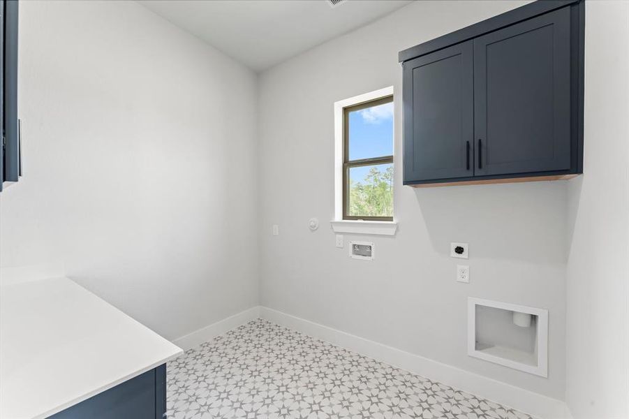 Utility Room with Washer and Dryer Connections, Storage Cabinets, and Pattern Tile Flooring