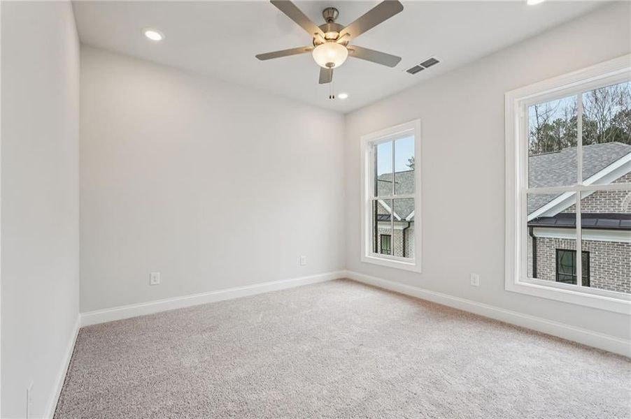 Spare room featuring light carpet, recessed lighting, and ceiling fan