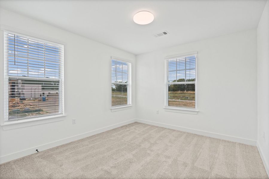 Recessed ceiling lighting, three windows with horizontal blinds, neutral wall paint, and light-toned carpet flooring
