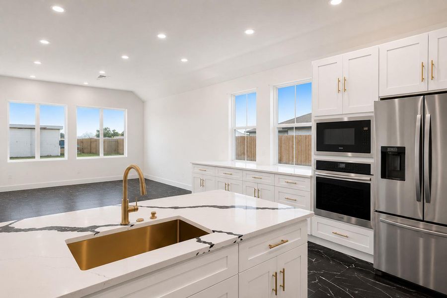 A well-equipped kitchen features a statement island with a gold sink, ideal for entertaining.