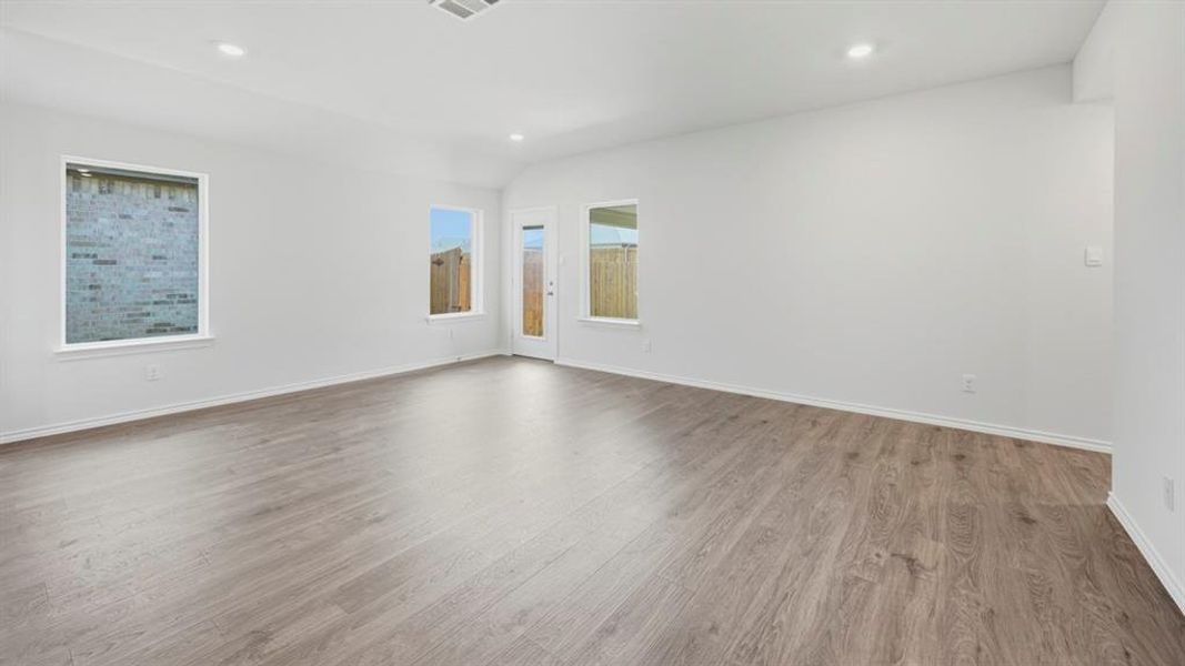 Empty room featuring wood finished floors, recessed lighting, and lofted ceiling Empty room featuring wood finished floors, recessed lighting, and lofted ceiling