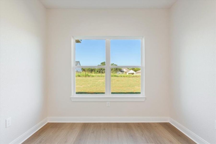Unfurnished room with baseboards and light wood-style flooring