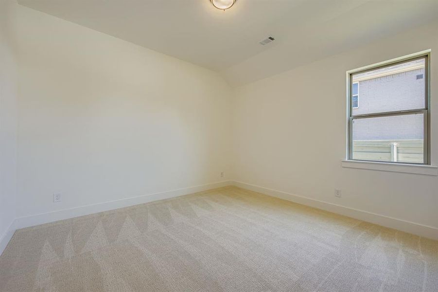 Empty room with light carpet and vaulted ceiling Empty room with light carpet and vaulted ceiling