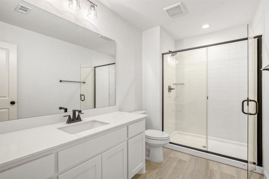 Bathroom featuring a shower stall, vanity, wood tiled floors, and recessed lighting