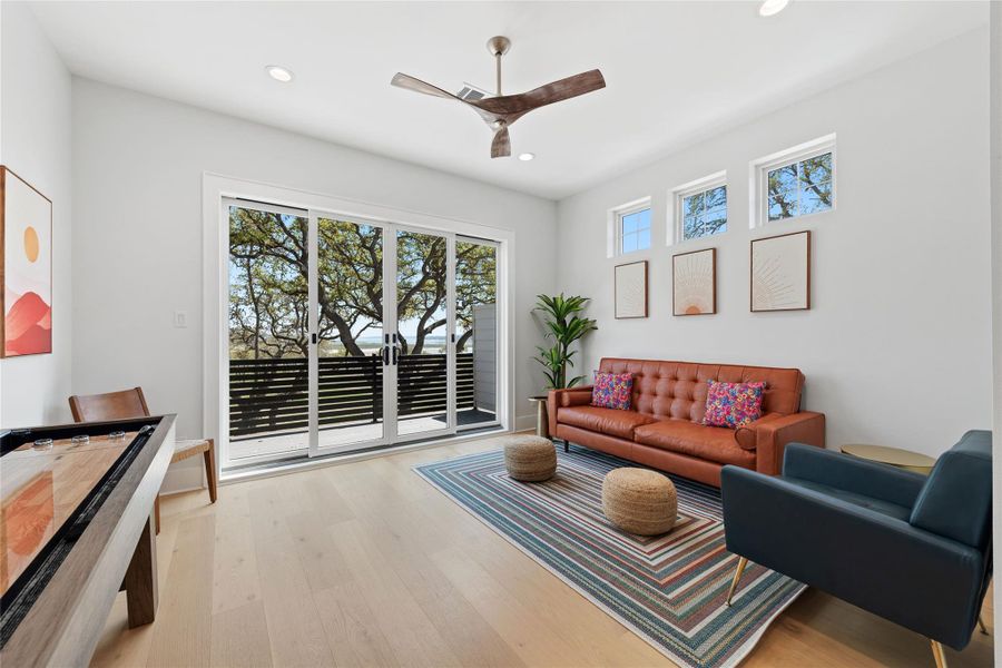 A sun-filled second living area offers soaring ceilings, expansive sliding glass doors to a private balcony, and sweeping views of the surrounding landscape. A sun-filled second living area offers soaring ceilings, expansive sliding glass doors to a private balcony, and sweeping views of the surrounding landscape.