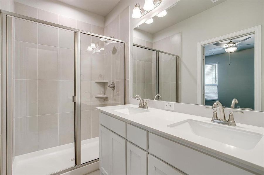 Bathroom with vanity, ceiling fan, and walk in shower