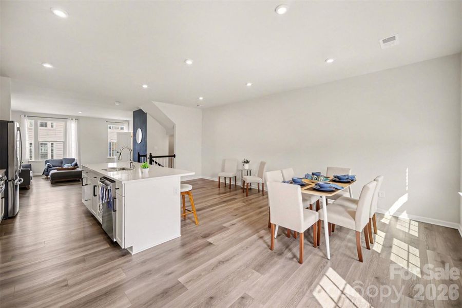 Bright open-concept, large kitchen island seamless flow into the dining area.