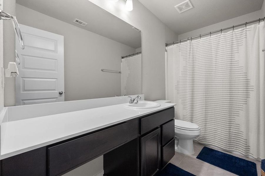 Upper level full size Bathroom featuring tile patterned flooring, vanity, and toilet