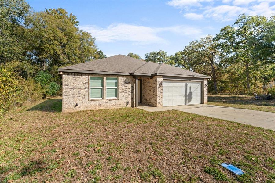 View of front facade with a front lawn and a garage