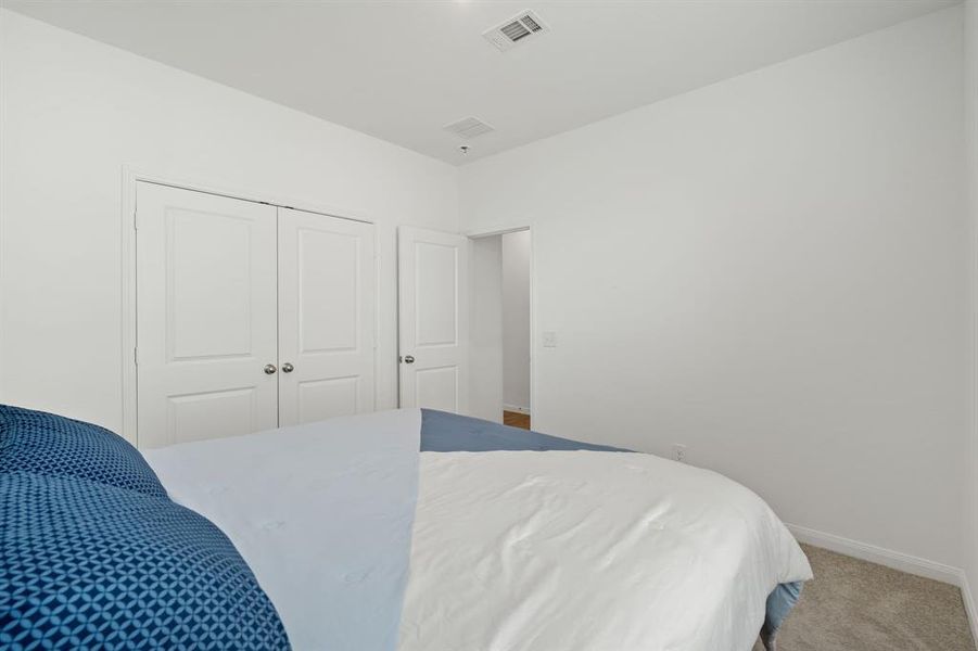 Another view of the Striking Secondary bedroom featuring plush carpet, oversized windows and double-door closet for added storage.