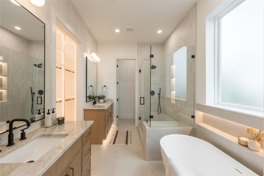 Mornings move easily in a bath built this way. Two vanities keep the routine separate and unhurried, the linen niche glows without a switch, and the floor seems to lift itself with the warm strip of light underneath. Everything is placed to feel quiet before the day gets loud.