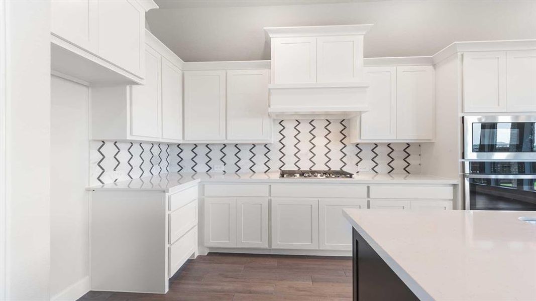 Kitchen featuring appliances with stainless steel finishes, white cabinetry, tasteful backsplash, and dark hardwood / wood-style floors