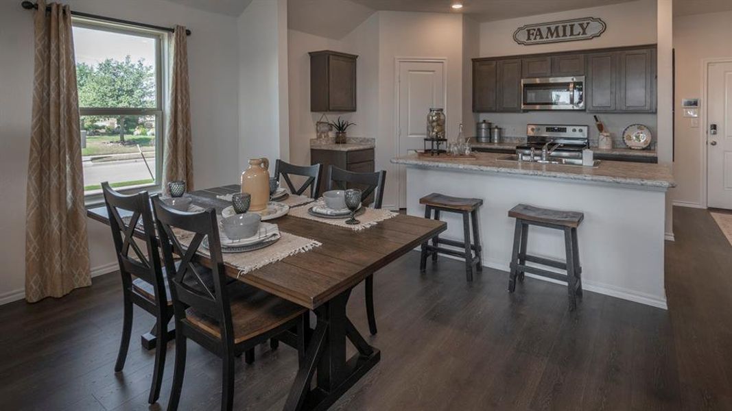 Dining area with dark wood-style floors and baseboards