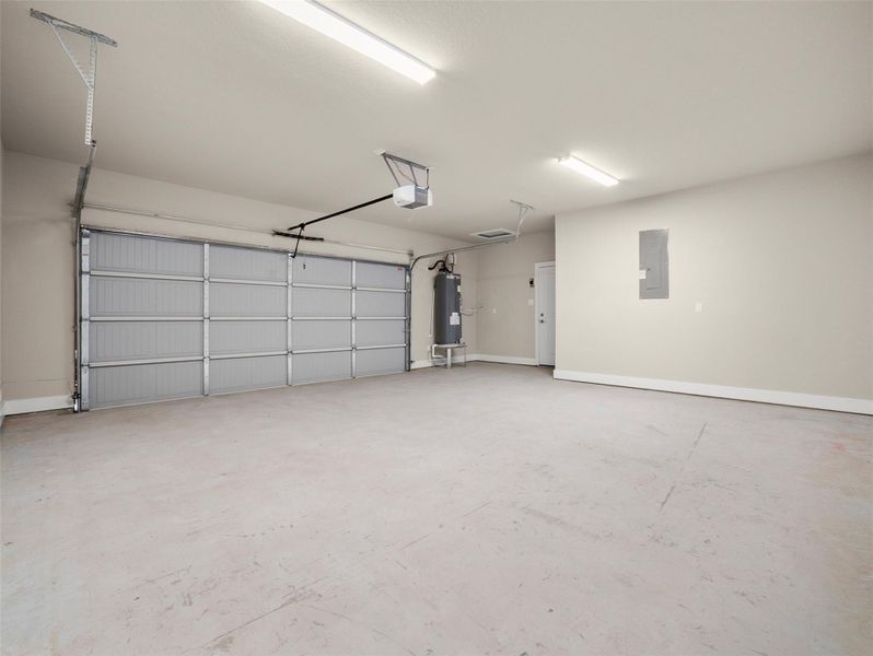 Garage featuring electric panel, electric water heater, and a garage door opener Garage featuring electric panel, electric water heater, and a garage door opener