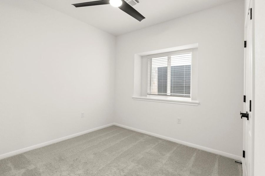 Spare room with carpet floors and a ceiling fan